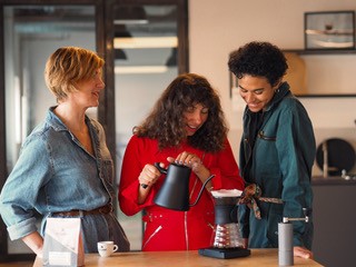Drei Latte-Art-Kaffeetassen, von oben fotografiert, an einem Holztisch.